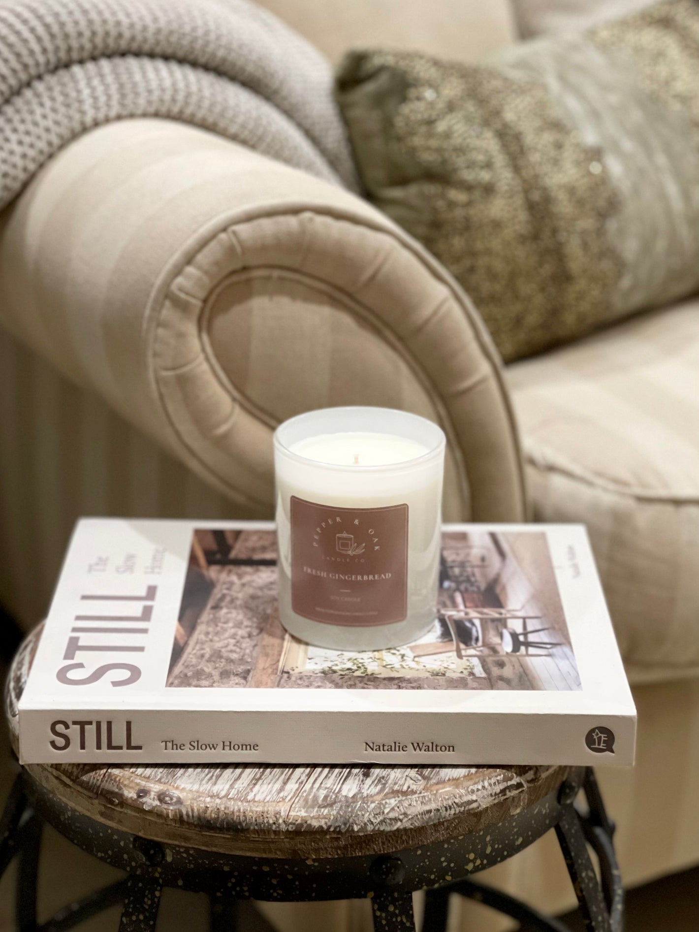 Large Soy fragranced candle in a luxurious lounge room placed on top of a home styling book